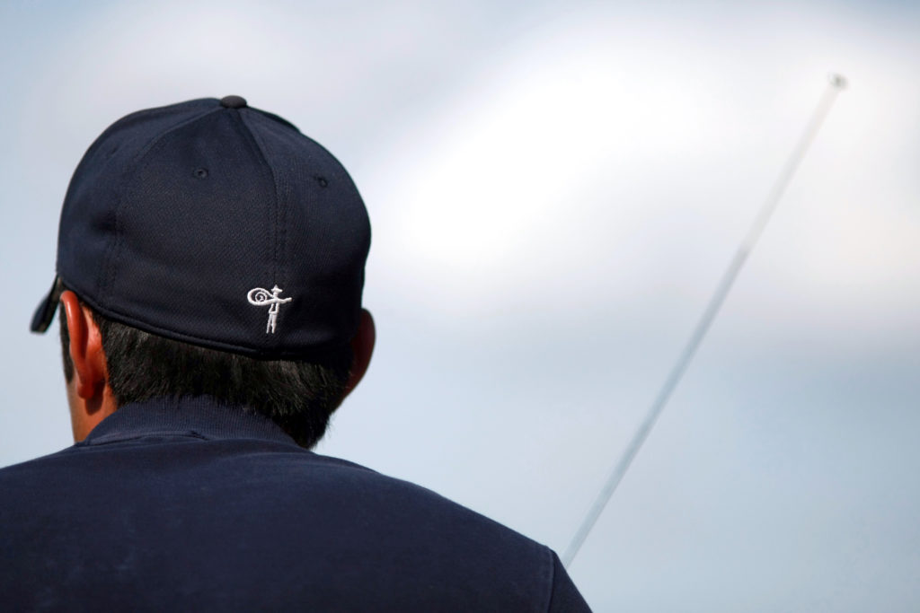 Man Fishing in Vaquero Club Logo Hat